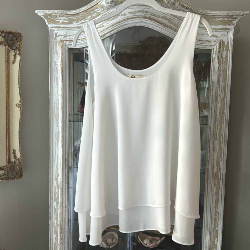 Adorable flowing  sleeveless blouse with layered ruffle.